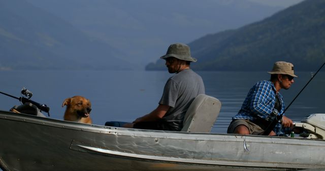 Two men and dog enjoying quiet time fishing on lake surrounded by mountains. Perfect for advertising outdoor recreational activities, travel destinations, dog-friendly vacations, and serene lifestyles.