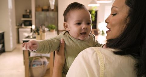 Mother holding baby in cozy home kitchen environment