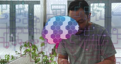 Man using tablet at desk with hexagonal brain hologram and circuit data overlay