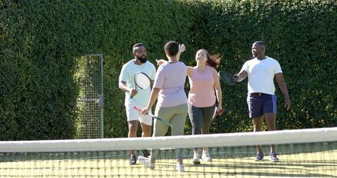 Diverse Friends Celebrating Tennis Victory on Sunlit Court