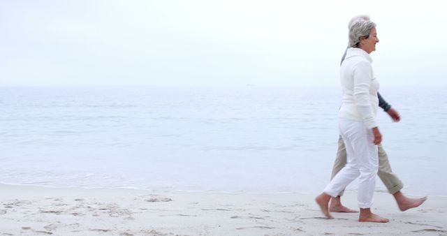 Senior Couple Walking Barefoot on Tranquil Beach - Download Free Stock Images Pikwizard.com