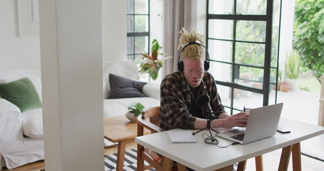 Young Man Working from Home with Laptop and Headphones in Cozy Living Room - Download Free Stock Images Pikwizard.com