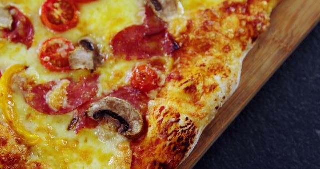 Close-up view of a mouth-watering pizza slice topped with melted cheese, mushrooms, cherry tomatoes, and pepperoni. Ideal for menus, food blogs, advertisements for pizza restaurants, and culinary websites.