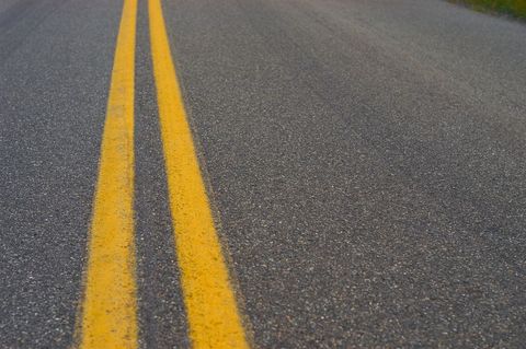 Close-Up View of Highway Double Yellow Lines