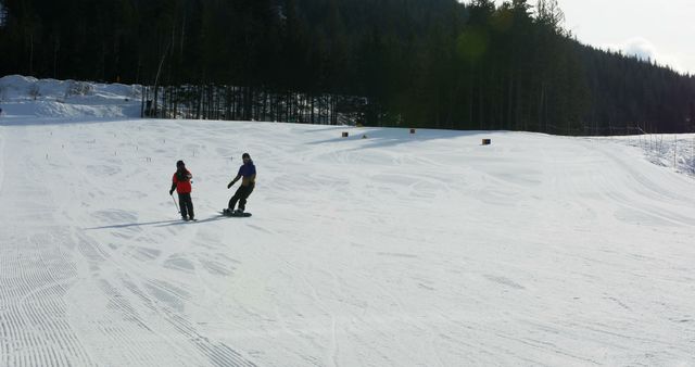 Two people, a young adult and a child, are snowboarding down a gentle slope, with copy space - Download Free Stock Photos Pikwizard.com