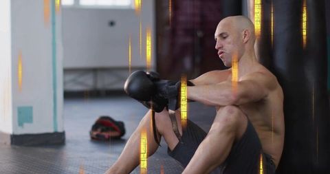 Tightening boxing gloves while resting beside heavy bag muscular boxer training focus