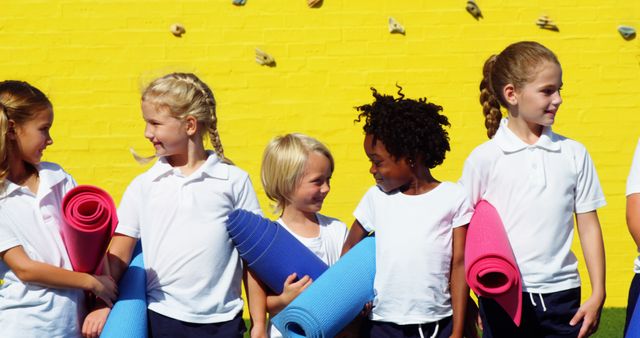 Diverse Group of Children with Yoga Mats in Front of Yellow Wall - Download Free Stock Images Pikwizard.com