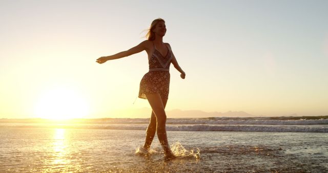 This image captures a joyful woman walking on the beach during sunset. Ideal for advertisements, travel brochures, wellness articles, and lifestyle blogs. Use it to portray summer activities, leisure moments, or vacation experiences.
