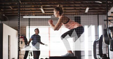 Woman performing box jump in modern gym for cardio training