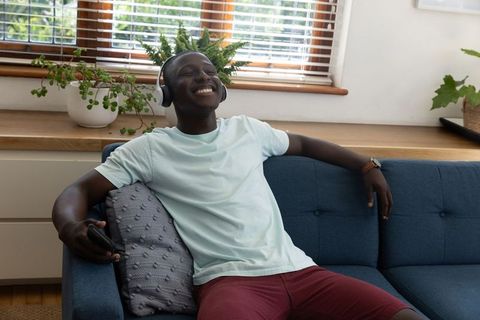 Relaxed Young Man Enjoying Music on Headphones at Home