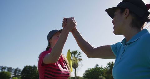 Two Women High-Fiving While Enjoying a Game of Golf