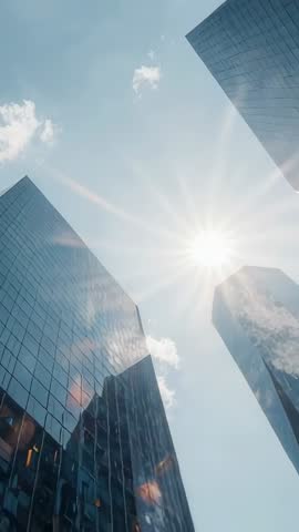 Vertical Tilt Video Capturing Sunflare Between Reflective Glass Skyscrapers