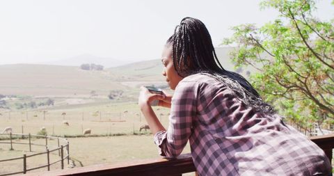 Woman Enjoying Coffee on Rustic Farm Balcony