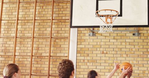 Energetic High School Students Playing Basketball Indoors