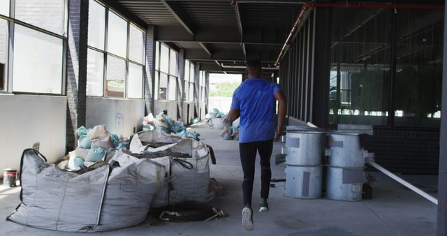 Man Running in Industrial Warehouse with Construction Materials - Download Free Stock Images Pikwizard.com