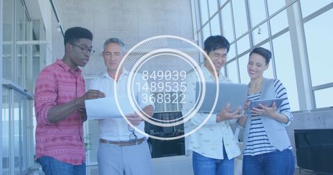 Diverse Business Team Reviewing Data with Digital Overlay in Modern Office