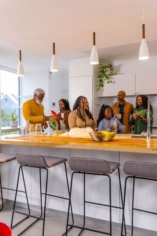 Multigenerational african american family gathering around sunlit modern kitchen island