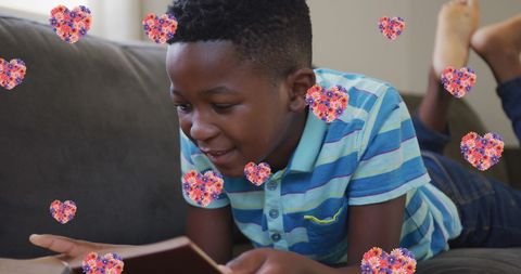 Smiling Boy Enjoys Reading Book with Floral Hearts