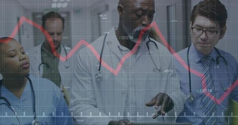 Medical team reviewing digital patient data on tablet with red descending chart overlay