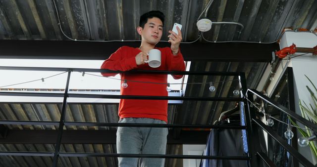 Man In Red Sweater Holding Mug And Looking At Smartphone - Download Free Stock Images Pikwizard.com