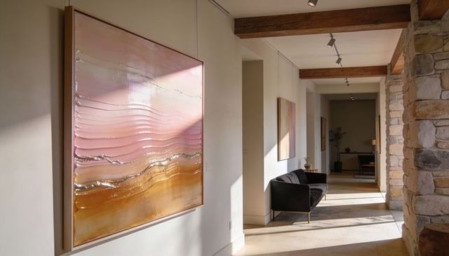 Sunlit modern hallway showing large textured abstract painting with metallic gradient