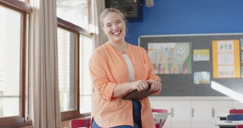 Smiling Teacher with Tablet in Creative Classroom Environment