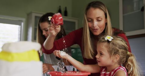 Happy Mother with Daughters Enjoying Baking Time in Kitchen