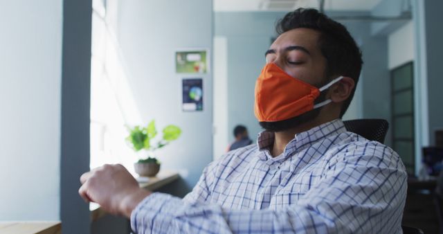 Office Worker with Mask Relaxing at Desk - Download Free Stock Images Pikwizard.com