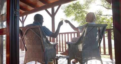 Senior Couple Enjoying Wine on Scenic Porch During Sunset
