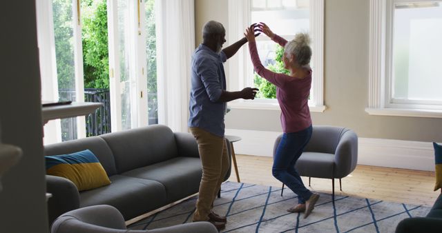 Biracial senior couple dancing together in the living room at home. retirement senior couple lifestyle self isolation in quarantine lockdown
