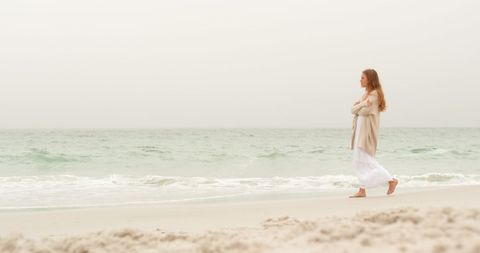 Woman Walking on Beach in Cozy Clothing