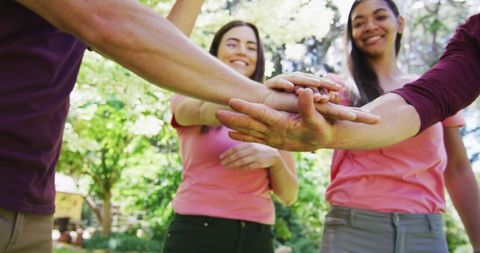 Diverse Group Celebrating Breast Cancer Awareness with Hands Stacking