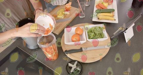 Women preparing fresh carrot smoothie in home kitchen, blender use, healthy meal prep
