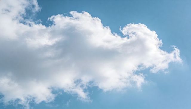 Sunlight Heating Fluffy Cumulus Cloud Drifting Across Clear Blue Sky Minimal Backdrop