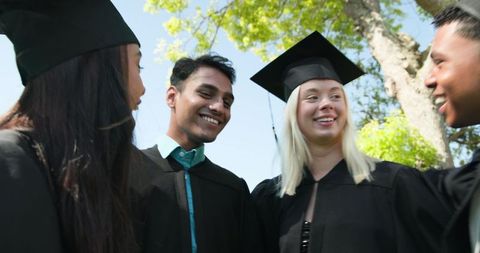Diverse group of graduates celebrating outdoors