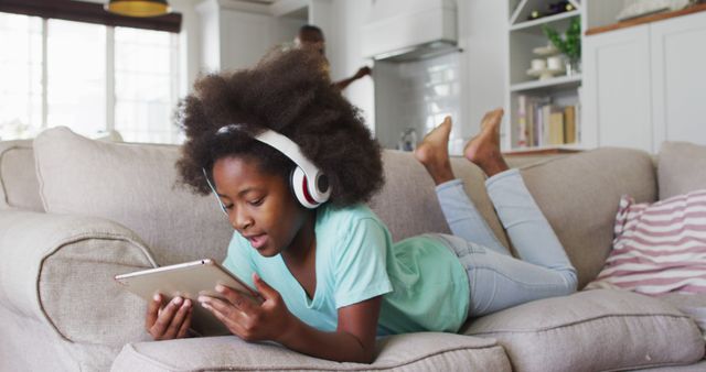 Young Girl Relaxing on Couch Listening to Music and Using Tablet - Download Free Stock Images Pikwizard.com