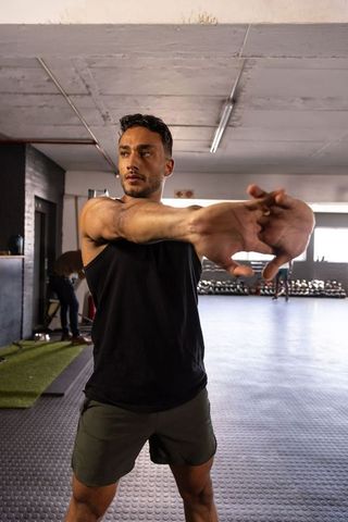 Man Stretching in Industrial Style Gym Enhancing Flexibility