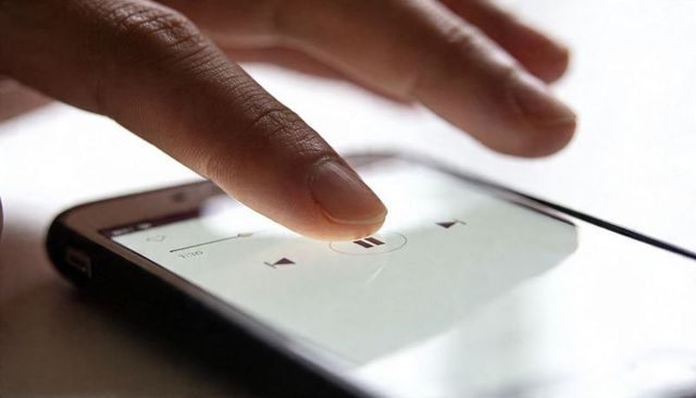 Index Finger Tapping Pause Button on Smartphone Media Player Closeup with Progress Bar
