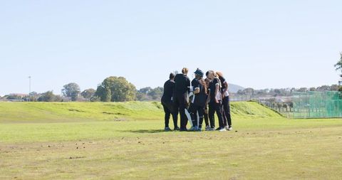 Diverse female softball team huddling for strategy session