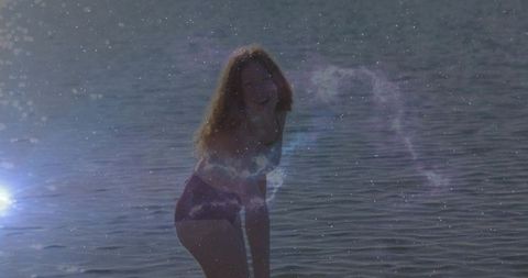 Woman in Swimwear Posing Joyfully by Sparkling Water