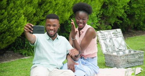 Joyful Couple Enjoying Picnic Outdoors Taking Selfie on Smartphone