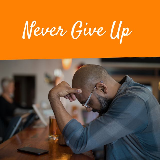 Image of never give up on orange background and sad african american man sitting in bar. Emotions, motivation and mental strength concept.