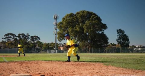 Baseball infield action featuring players in bright yellow uniforms near home plate