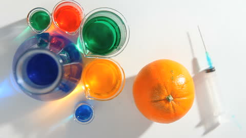 Colorful Chemical Experiment with Orange and Syringe in Lab