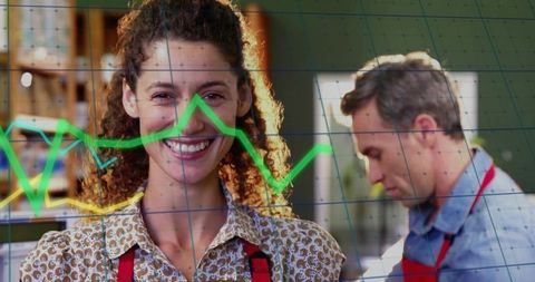 Smiling woman in red apron with analytics overlay | retail teamwork and productivity