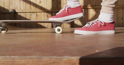 Skateboarding action with red sneakers on backyard ramp