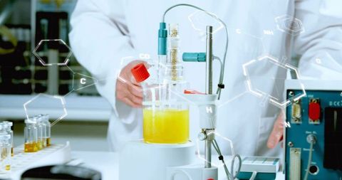 Senior chemist adjusting glass reactor with yellow solution at benchtop instruments