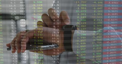 Businessman stamping documents with stock market data overlay