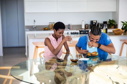 Diverse Couple Enjoying Meal at Home in Modern Kitchen