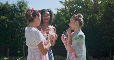 Women Relaxing with Drinks in Garden on Sunny Day